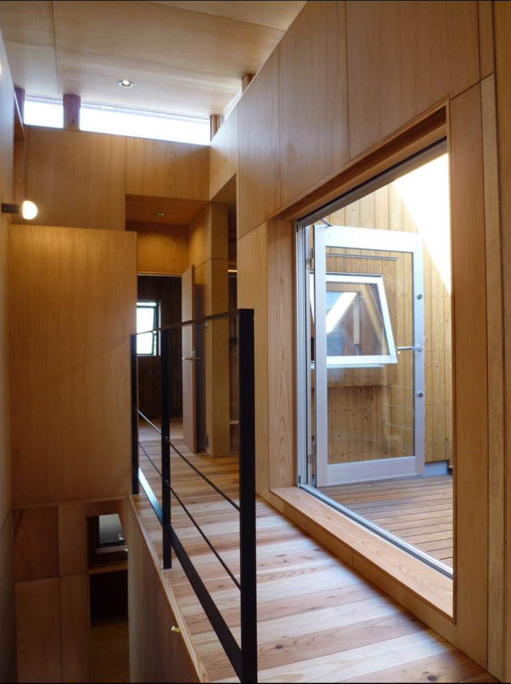 Imagen de recibidores y pasillos modernos de tamaño medio con paredes beige, suelo de madera clara, suelo beige, bandeja y madera