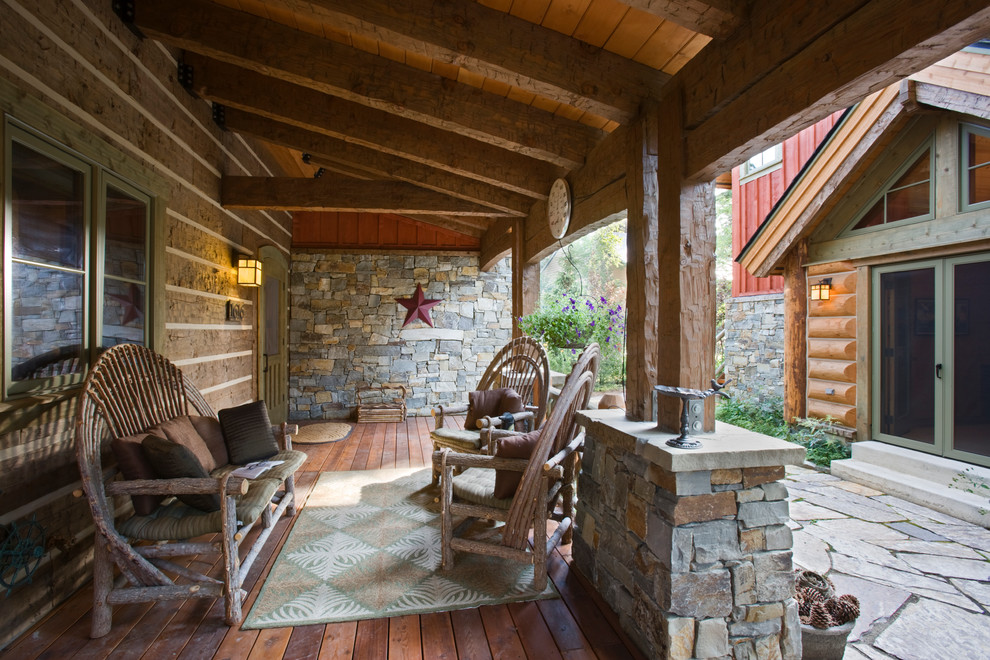 Mid-sized mountain style stone front porch photo in Boise with a roof extension