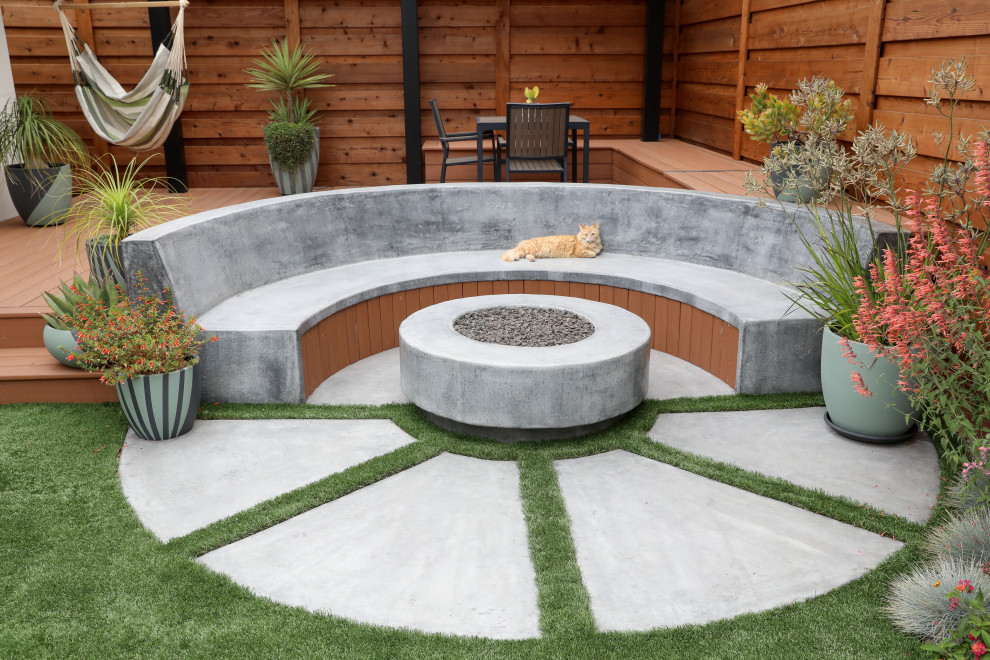 Photo of a medium sized modern back xeriscape full sun garden for summer in Other with a fire feature, concrete paving and a metal fence.