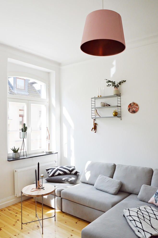Design ideas for a small scandinavian enclosed living room in Dusseldorf with white walls and light hardwood floors.