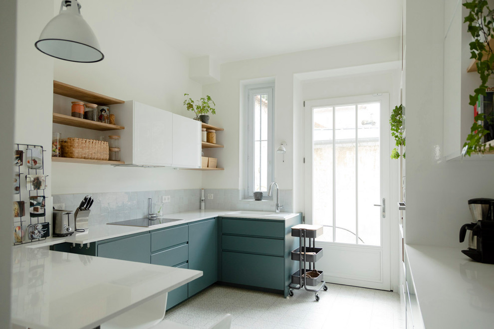 Design ideas for a large u-shaped eat-in kitchen in Paris with a single-bowl sink, flat-panel cabinets, green cabinets, quartzite benchtops, white splashback, terra-cotta splashback, panelled appliances, cement tiles, a peninsula, grey floor and white benchtop.