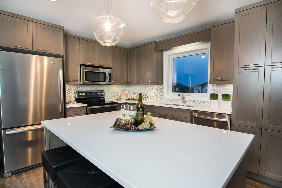 Example of a mid-sized transitional l-shaped dark wood floor and brown floor eat-in kitchen design with an undermount sink, shaker cabinets, brown cabinets, quartzite countertops, white backsplash, stainless steel appliances and an island