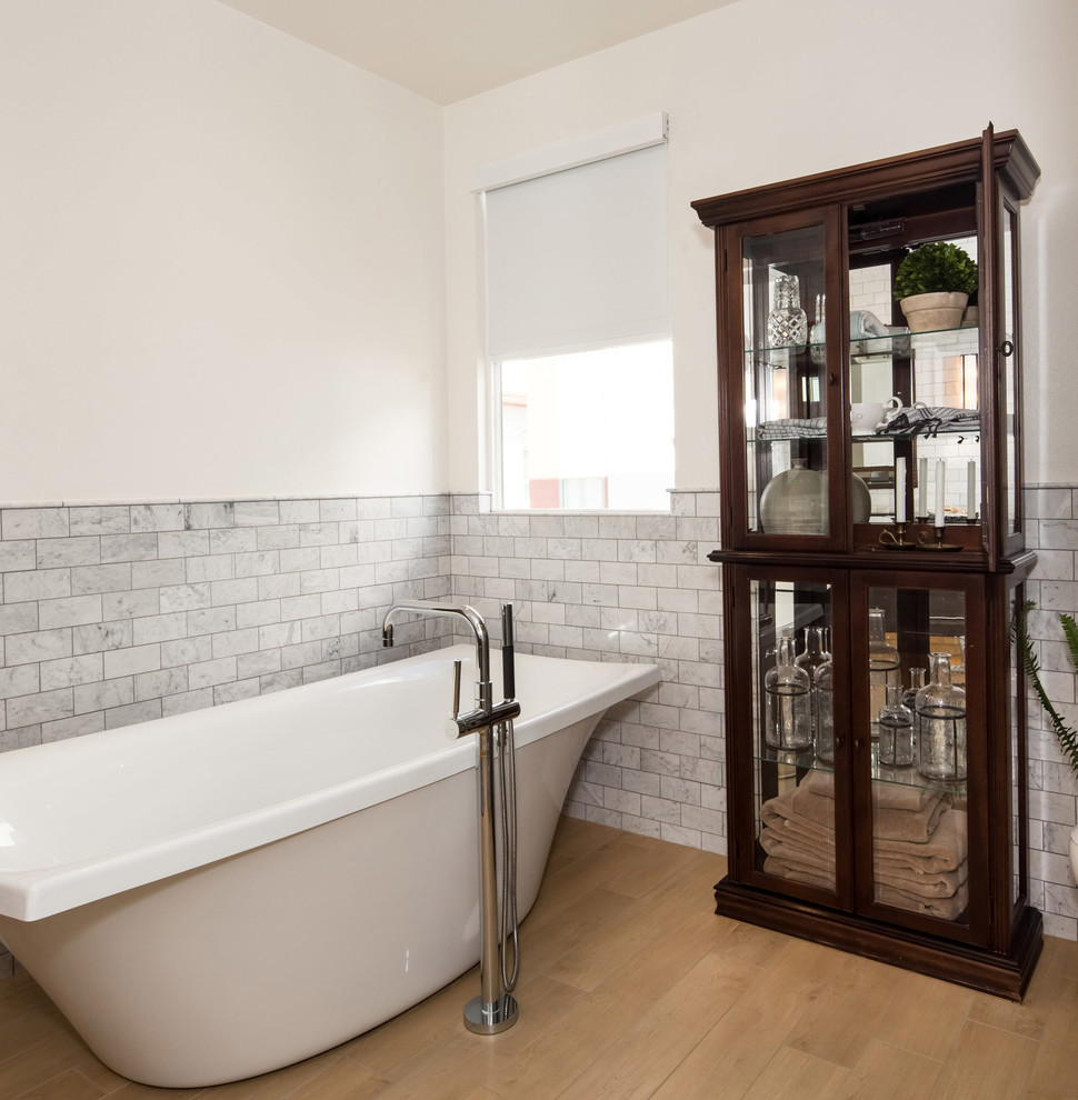 Photo of a mid-sized country master bathroom in Los Angeles with shaker cabinets, dark wood cabinets, a freestanding tub, a corner shower, a one-piece toilet, yellow tile, subway tile, white walls, light hardwood floors, an undermount sink and engineered quartz benchtops.