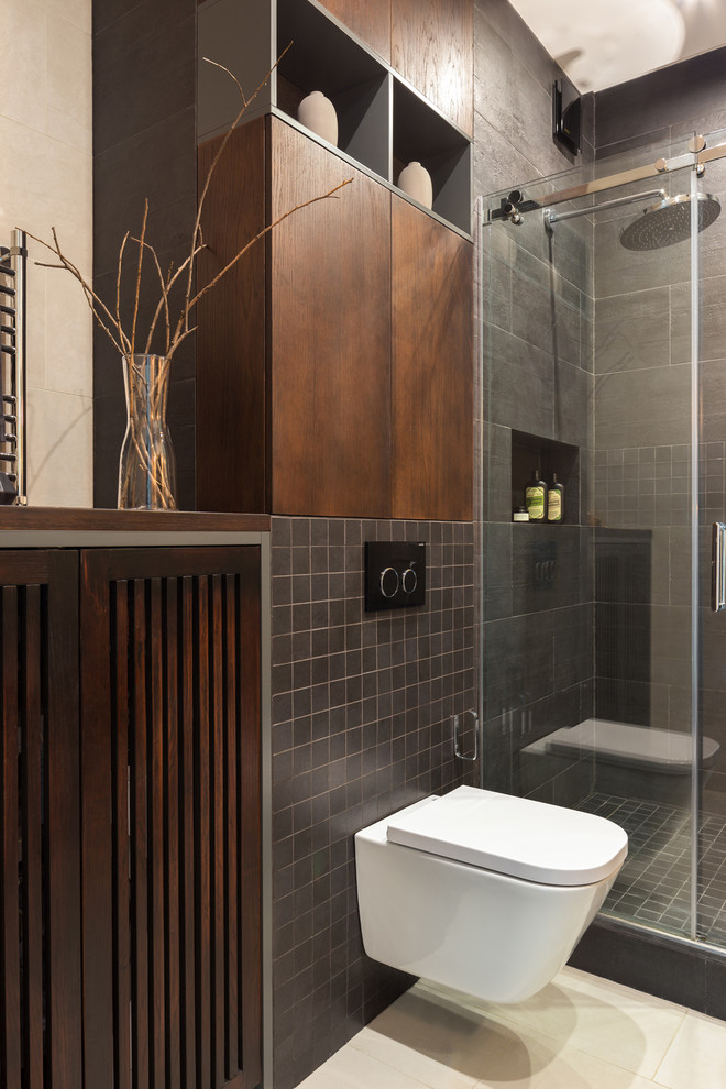Inspiration for a small contemporary 3/4 wet room bathroom in Moscow with flat-panel cabinets, dark wood cabinets, a wall-mount toilet, black tile, porcelain tile, beige walls, ceramic floors, a vessel sink, solid surface benchtops, beige floor, a sliding shower screen and black benchtops.