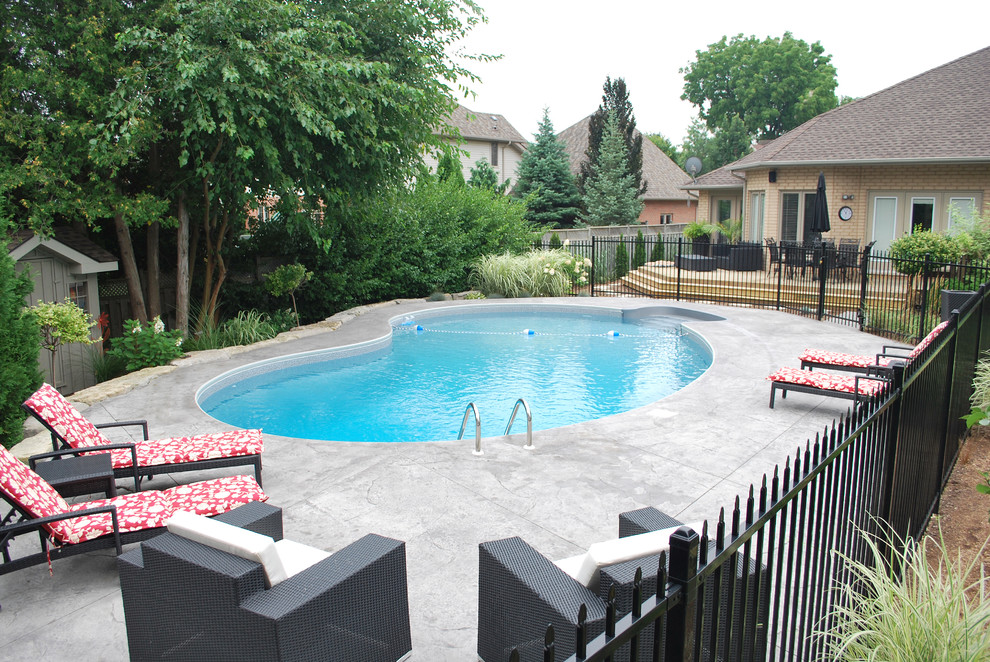 This is an example of a mid-sized contemporary backyard custom-shaped pool in Toronto with concrete slab.
