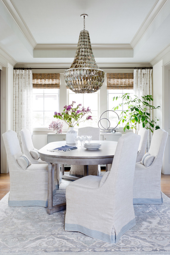 Photo of a beach style dining room in Los Angeles with white walls, medium hardwood floors and grey floor.