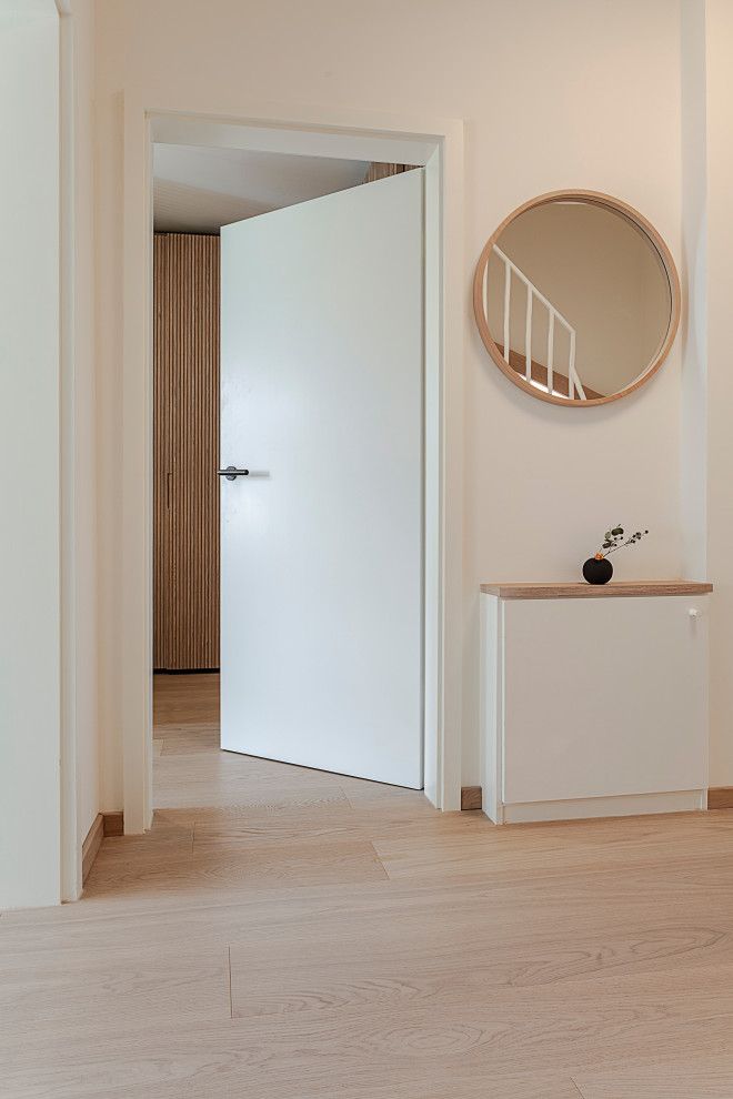 Inspiration for a small asian hallway in Munich with white walls, light hardwood floors and beige floor.