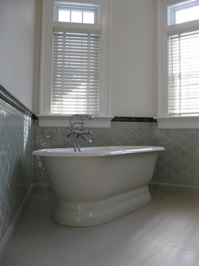 This is an example of a traditional bathroom in Boston with a freestanding tub, gray tile, ceramic tile and grey floor.