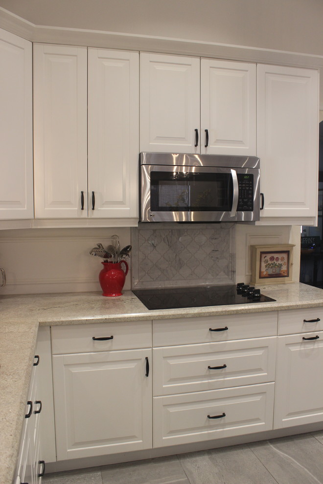 Enclosed kitchen - mid-sized transitional u-shaped ceramic tile enclosed kitchen idea in Phoenix with a double-bowl sink, raised-panel cabinets, white cabinets, marble countertops, gray backsplash, ceramic backsplash, stainless steel appliances and an island