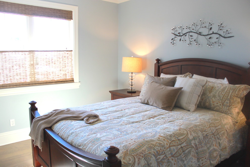 This is an example of a mid-sized traditional guest bedroom in San Francisco with grey walls, medium hardwood floors, no fireplace and brown floor.