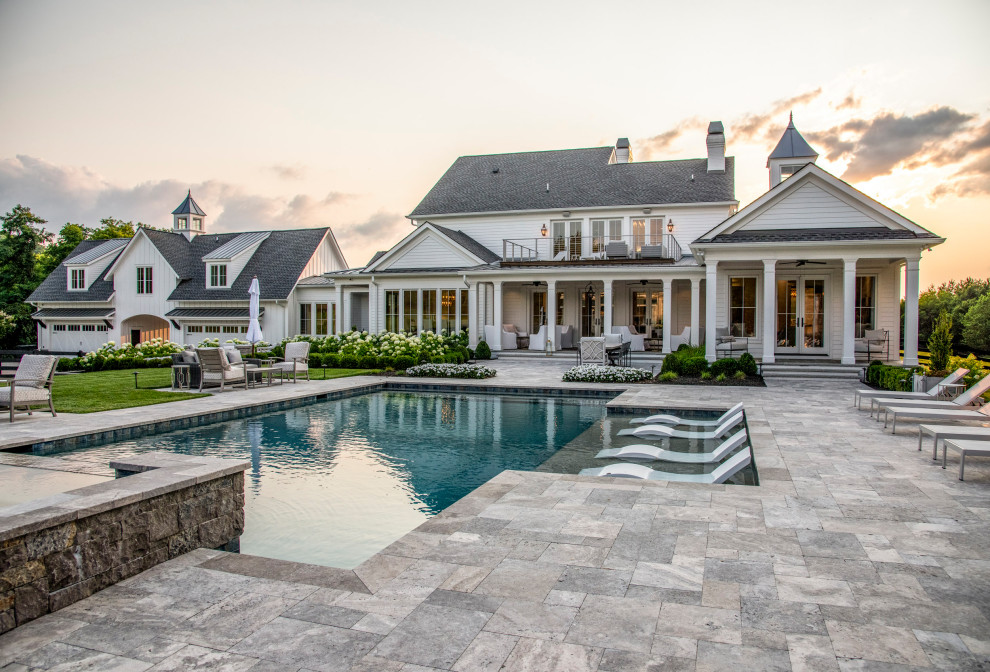 Design ideas for a large country backyard custom-shaped pool in Nashville with natural stone pavers.