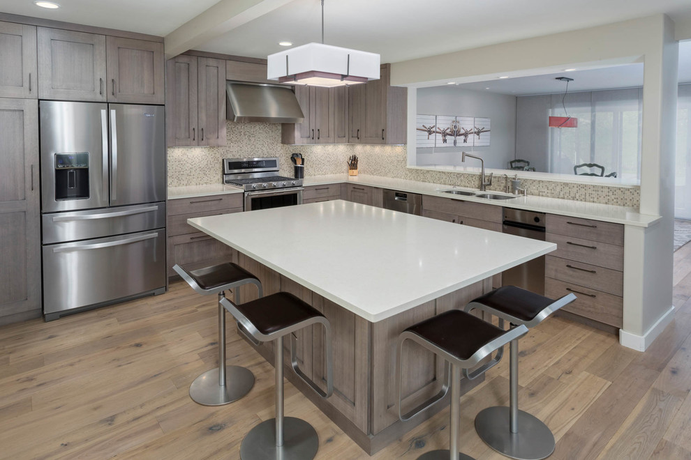 Example of a large transitional l-shaped medium tone wood floor and brown floor eat-in kitchen design in Denver with a double-bowl sink, shaker cabinets, medium tone wood cabinets, quartz countertops, multicolored backsplash, mosaic tile backsplash, stainless steel appliances, an island and white countertops