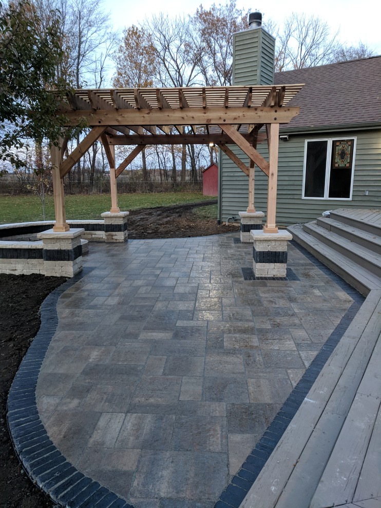 Inspiration for a mid-sized transitional backyard patio in Chicago with a fire feature, stamped concrete and a pergola.