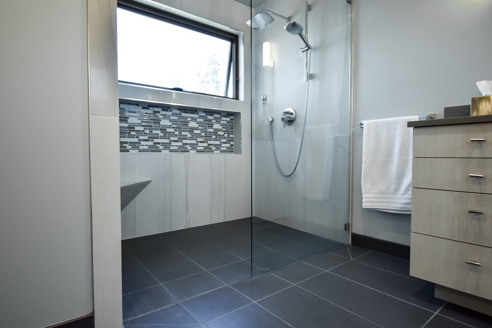 Design ideas for a large modern master bathroom in Seattle with flat-panel cabinets, beige cabinets, a curbless shower, a one-piece toilet, blue walls, an undermount sink, black floor, an open shower and grey benchtops.