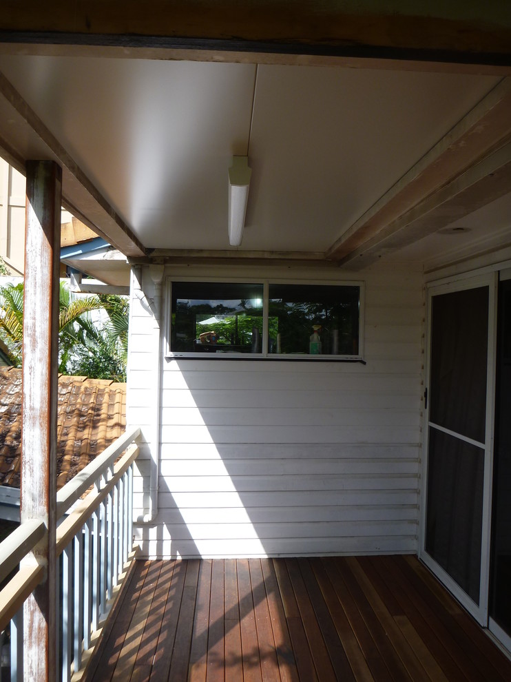 This is an example of a small traditional rooftop deck in Brisbane with a roof extension.