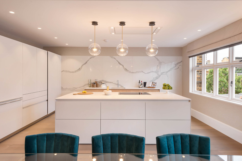 Inspiration for a contemporary l-shaped eat-in kitchen in London with an undermount sink, flat-panel cabinets, white cabinets, white splashback, marble splashback, panelled appliances, light hardwood floors and with island.