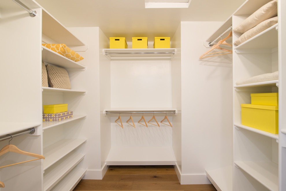 Example of a mid-sized beach style gender-neutral medium tone wood floor walk-in closet design in San Diego with open cabinets and white cabinets