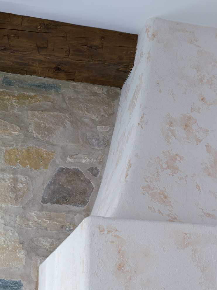 Inredning av ett stort vit vitt kök, med en rustik diskho, luckor med upphöjd panel, beige skåp, marmorbänkskiva, flerfärgad stänkskydd, stänkskydd i sten, rostfria vitvaror, mörkt trägolv, en köksö och brunt golv