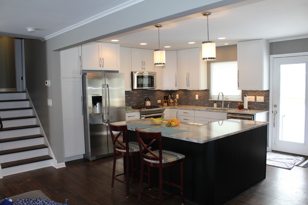 Mid-sized transitional l-shaped dark wood floor open concept kitchen photo in Columbus with an undermount sink, shaker cabinets, white cabinets, marble countertops, gray backsplash and an island