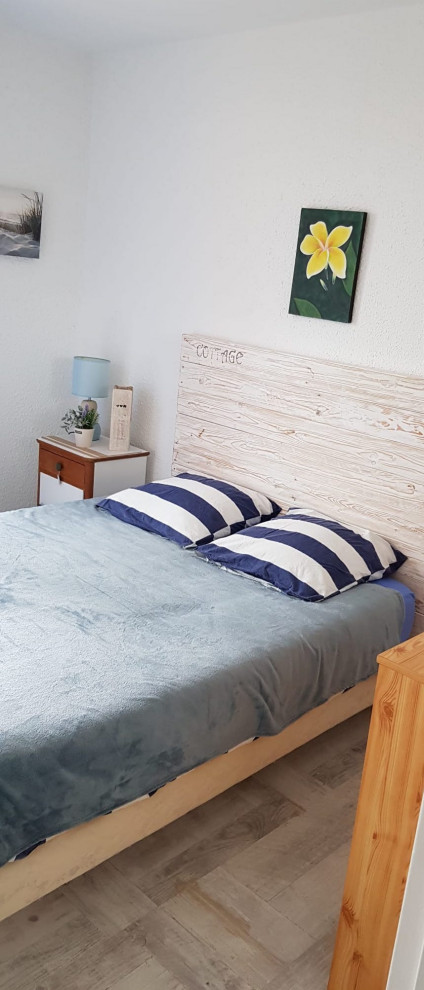 Mittelgroßes Maritimes Hauptschlafzimmer mit weißer Wandfarbe, hellem Holzboden und grauem Boden in Sonstige