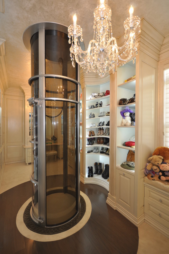 Inspiration for a traditional women's dressing room in New York with raised-panel cabinets, beige cabinets and dark hardwood floors.