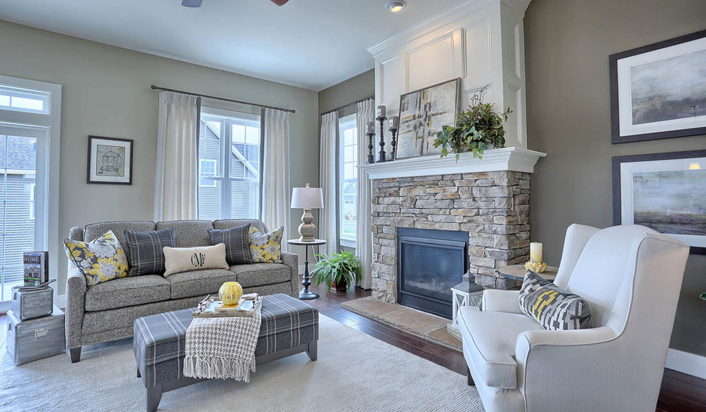 Photo of a mid-sized arts and crafts open concept family room in Other with grey walls, dark hardwood floors, a standard fireplace, a stone fireplace surround, no tv and brown floor.