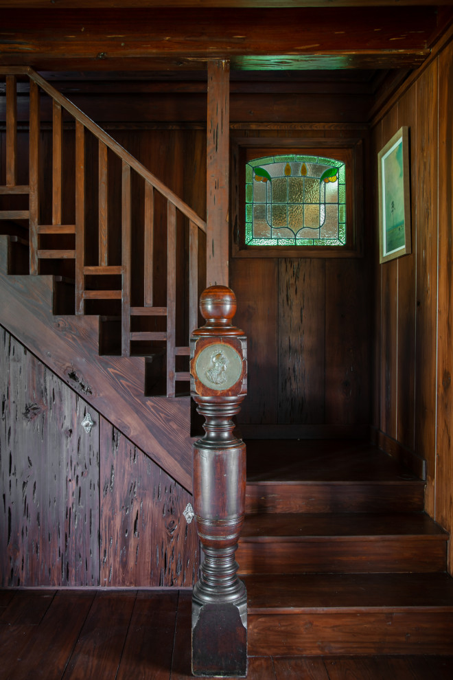 Foto di una piccola scala a "L" country con pedata in legno, alzata in legno, parapetto in legno e pareti in legno