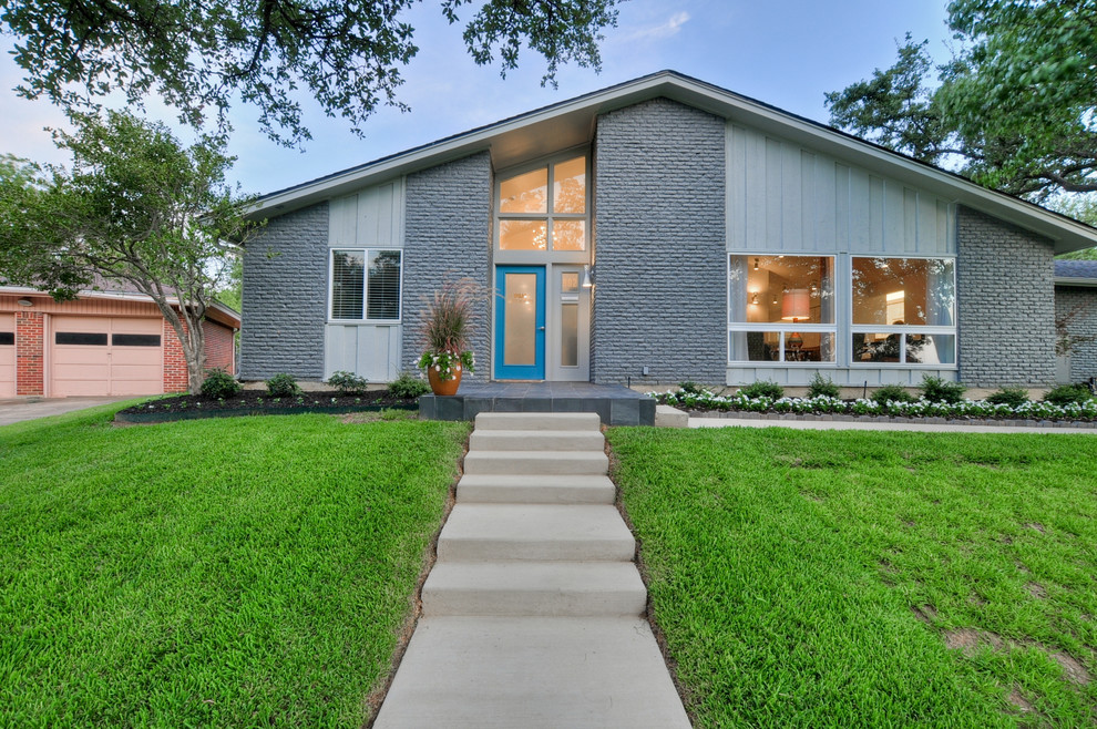 Photo of a mid-sized midcentury one-storey brick grey exterior in Dallas with a gable roof.