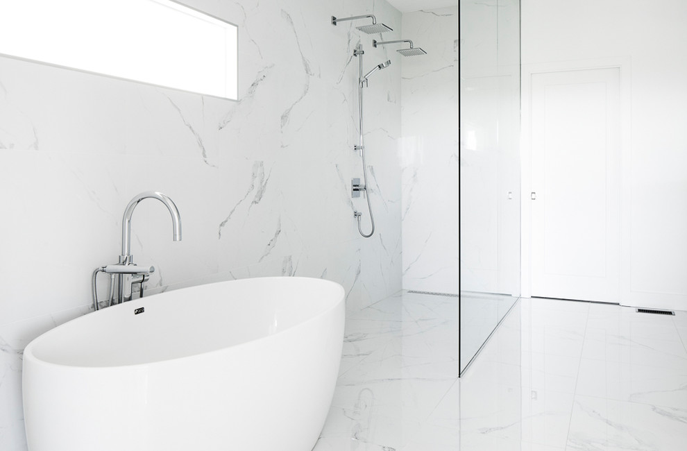 Contemporary master bathroom in Montreal with white cabinets, a freestanding tub, a curbless shower, a one-piece toilet, white tile, marble, white walls, marble floors, white floor, an open shower and white benchtops.