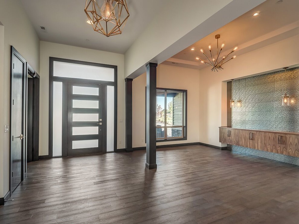 Design ideas for a large modern foyer in Portland with white walls, dark hardwood floors, a single front door, a dark wood front door and brown floor.