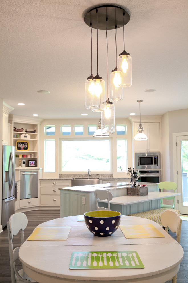 Transitional medium tone wood floor eat-in kitchen photo with flat-panel cabinets, white cabinets, granite countertops, stainless steel appliances and an island