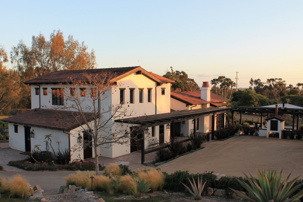 Imagen de fachada de casa blanca y roja de estilo americano de tamaño medio de tres plantas con revestimiento de estuco, tejado a dos aguas y tejado de teja de barro