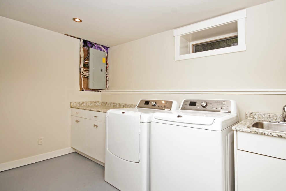 Photo of a mid-sized transitional single-wall dedicated laundry room in Calgary with a drop-in sink, white cabinets, granite benchtops, white walls and a side-by-side washer and dryer.