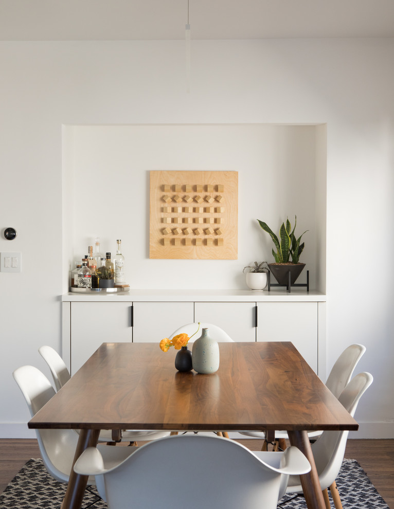 Inspiration for a mid-sized scandinavian separate dining room in San Francisco with white walls, dark hardwood floors and brown floor.