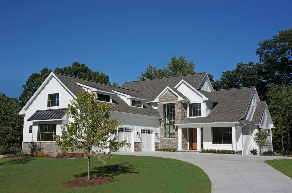 Mid-sized country three-storey white house exterior in Grand Rapids with a gable roof, a shingle roof, concrete fiberboard siding and board and batten siding.