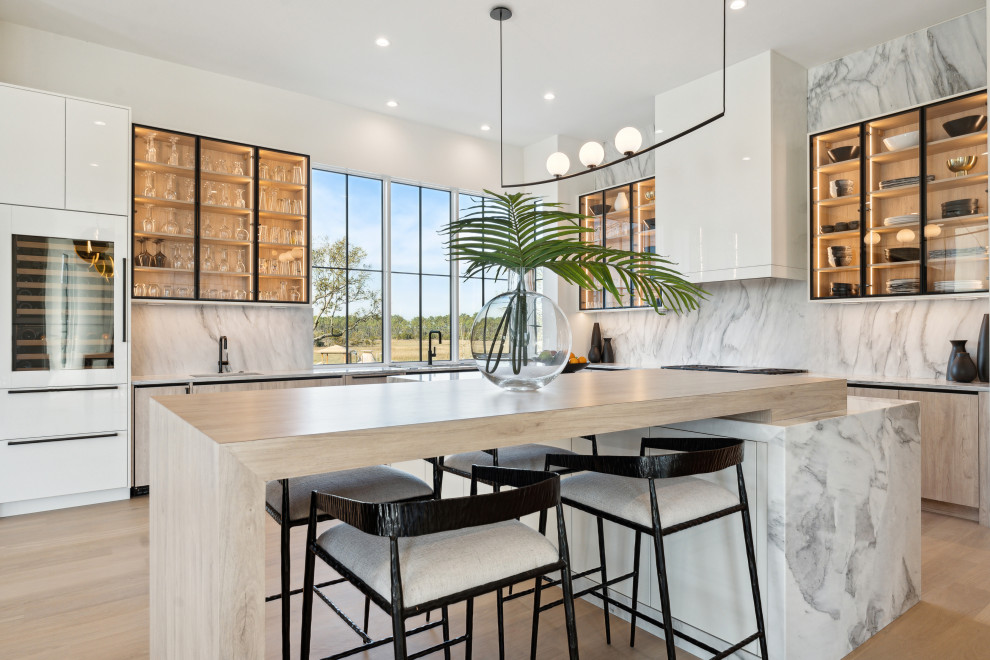 Inspiration for a huge contemporary u-shaped eat-in kitchen remodel in Charleston with a single-bowl sink, glass-front cabinets, black cabinets, marble countertops, white backsplash, marble backsplash, paneled appliances, an island and white countertops