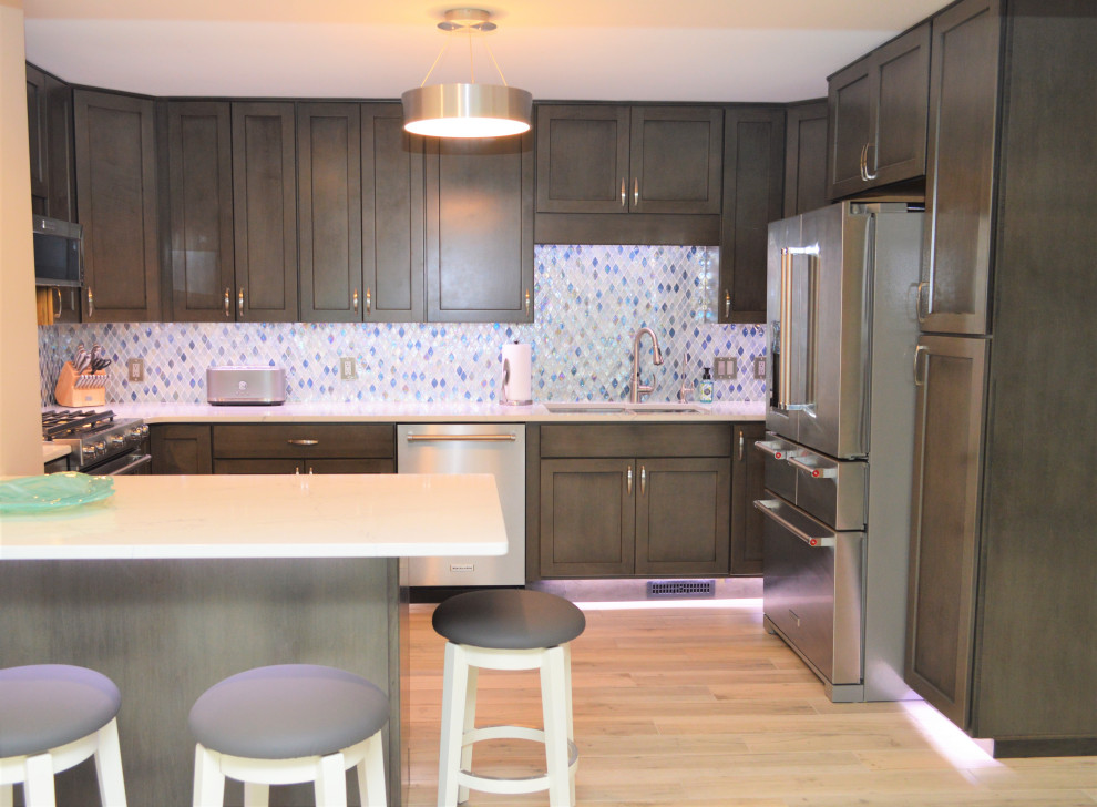 Idéer för att renovera ett mellanstort funkis vit vitt kök, med en undermonterad diskho, skåp i shakerstil, skåp i mellenmörkt trä, bänkskiva i kvartsit, blått stänkskydd, stänkskydd i keramik, rostfria vitvaror, ljust trägolv, en köksö och brunt golv