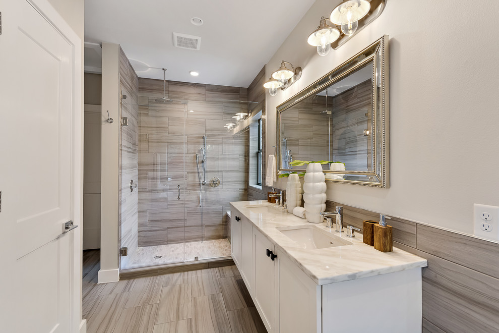 This is an example of a mid-sized contemporary master bathroom in Austin with shaker cabinets, white cabinets, a drop-in tub, an alcove shower, a one-piece toilet, white tile, porcelain tile, white walls, porcelain floors, an undermount sink, beige floor, a hinged shower door and quartzite benchtops.