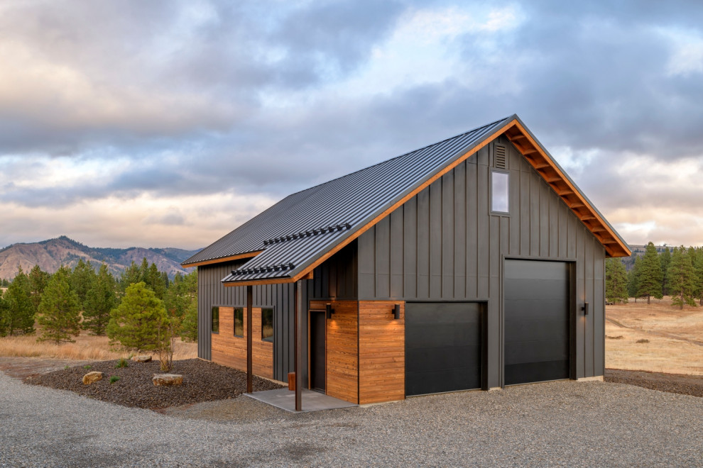 Idée de décoration pour une grande façade de maison noire champêtre en bois avec un toit à deux pans, un toit en métal et un toit noir.