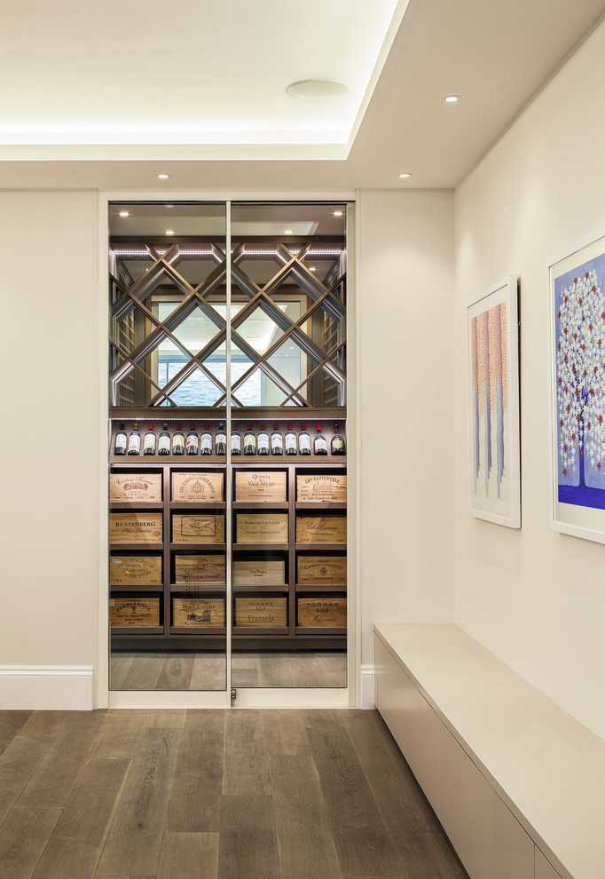 Photo of a mid-sized contemporary wine cellar in London with display racks.