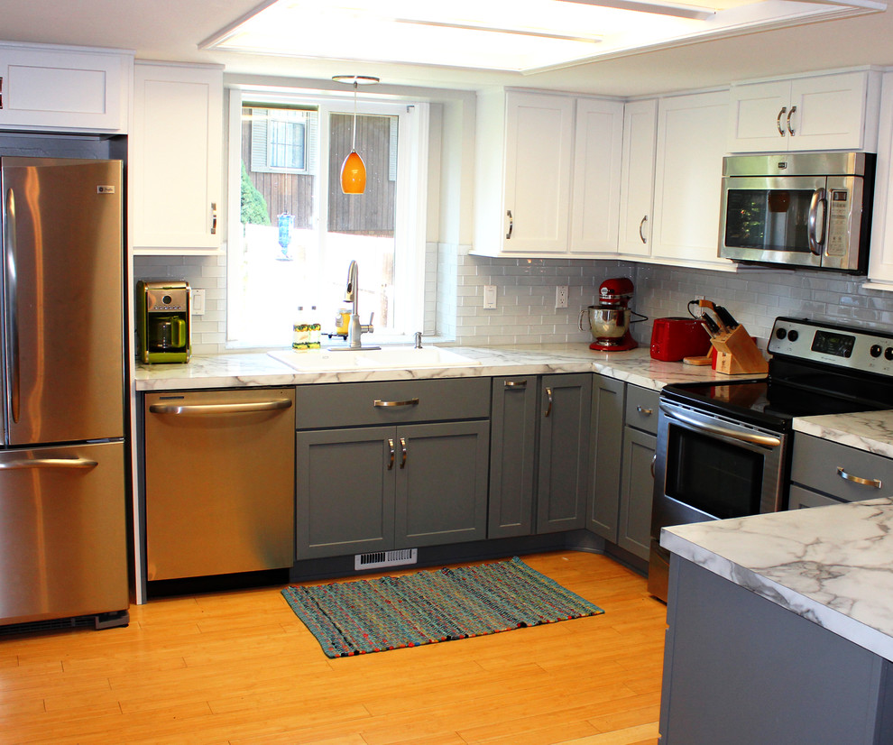Mid-sized transitional u-shaped bamboo floor eat-in kitchen photo in Boise with a drop-in sink, shaker cabinets, gray cabinets, laminate countertops, white backsplash, glass tile backsplash and stainless steel appliances
