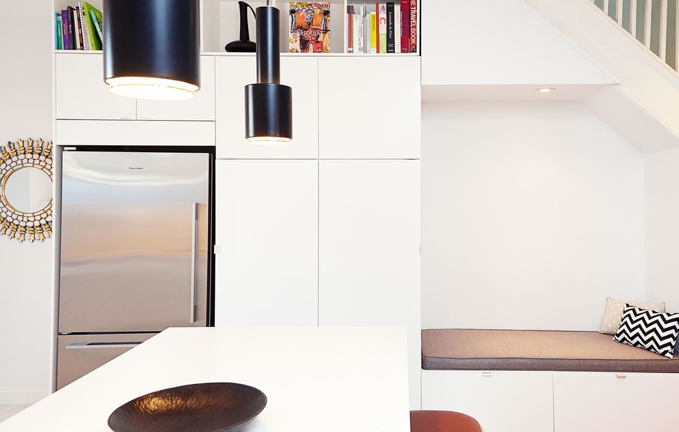 Photo of a mid-sized modern u-shaped open plan kitchen in Toronto with an undermount sink, flat-panel cabinets, white cabinets, solid surface benchtops, grey splashback, stone slab splashback, stainless steel appliances, marble floors and a peninsula.
