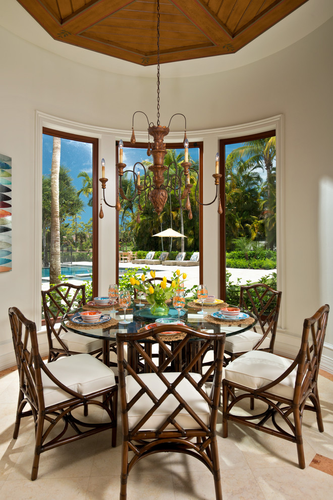 This is an example of a large tropical dining room in Miami with white walls.