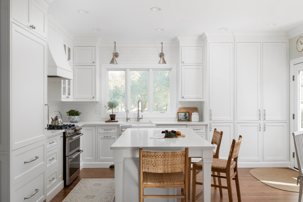 Foto på ett mellanstort vintage vit kök, med en rustik diskho, luckor med profilerade fronter, vita skåp, bänkskiva i kvarts, vitt stänkskydd, stänkskydd i keramik, integrerade vitvaror, mellanmörkt trägolv, en köksö och brunt golv