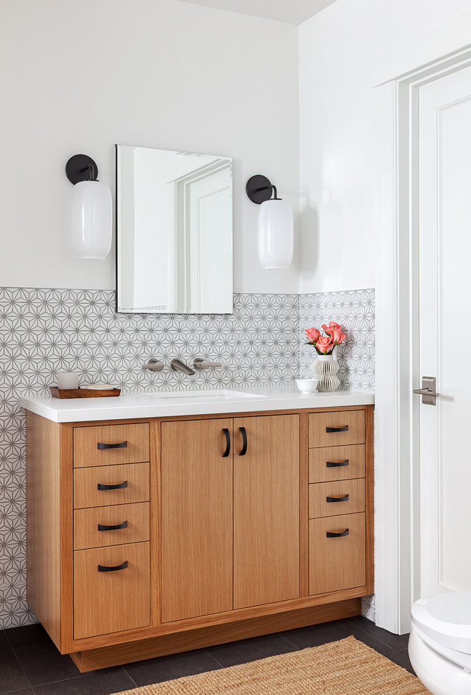 This is an example of a mid-sized eclectic master bathroom in San Francisco with recessed-panel cabinets, medium wood cabinets, a curbless shower, a one-piece toilet, white tile, mosaic tile, white walls, porcelain floors, an undermount sink, engineered quartz benchtops, grey floor, a hinged shower door and white benchtops.