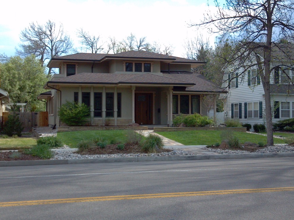 Mid-sized midcentury two-storey stucco beige exterior in Denver with a hip roof.
