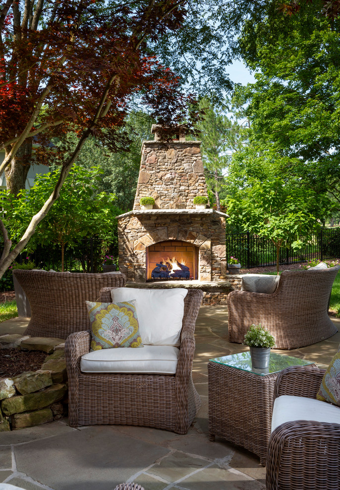 Design ideas for a mid-sized traditional backyard patio in Charlotte with with fireplace, natural stone pavers and no cover.