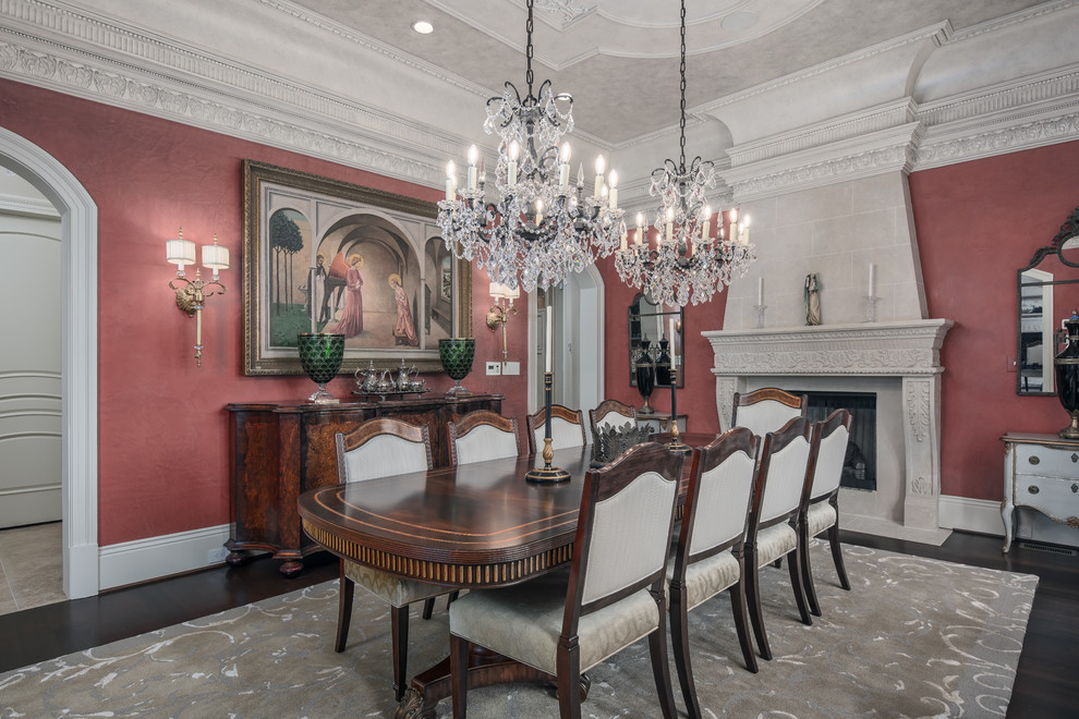 Traditional separate dining room in DC Metro with red walls, dark hardwood floors, a standard fireplace, a stone fireplace surround and brown floor.