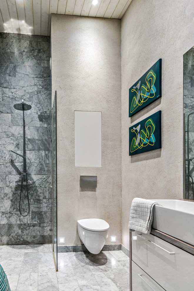 Small scandinavian master wet room bathroom in Stockholm with a wall-mount toilet, marble, marble floors, wood benchtops, an open shower, flat-panel cabinets, gray tile, beige walls, a vessel sink and grey floor.