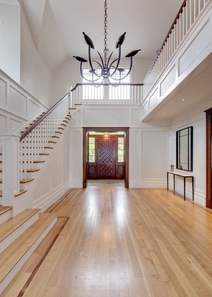 This is an example of an expansive traditional foyer in New York with white walls.